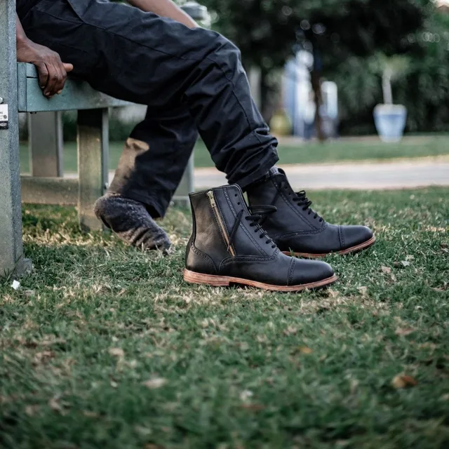 Black zip-side boots, worn, on grass